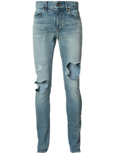 джинсы с рваными деталями Saint Laurent
