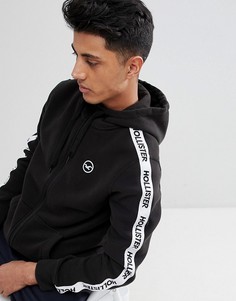 Худи черного цвета на молнии с лентой и логотипом Hollister Athletic - Черный