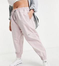 Тканые штаны светло-розового цвета с логотипом-галочкой Nike Plus-Розовый цвет